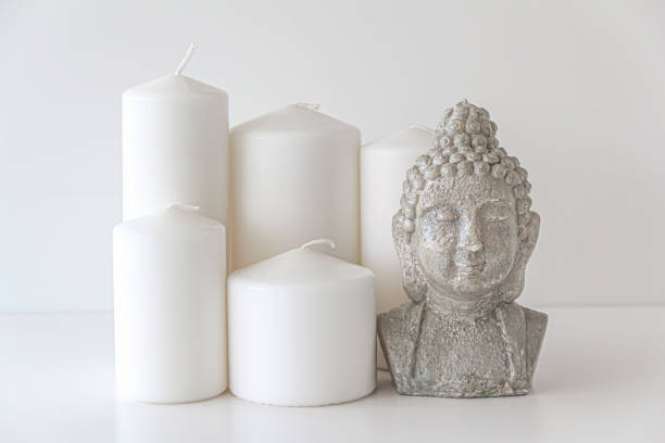 bougies blanches en forme de cylindre et bougie de figure de bouddha - sculpture contemporary buddha sparse photos et images de collection