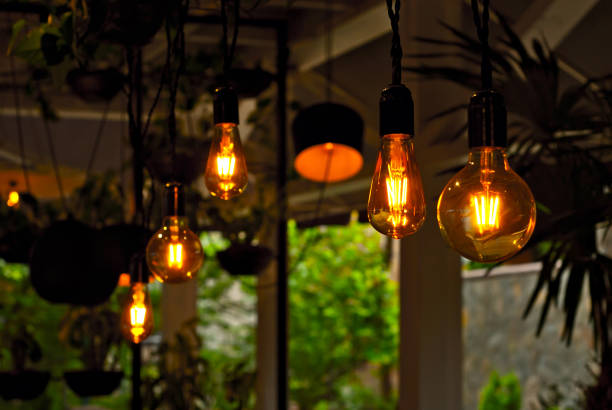 istock Yellow light bulbs as a design element. Greens and flowerpots in the background. Layout for interior design. 1250214551