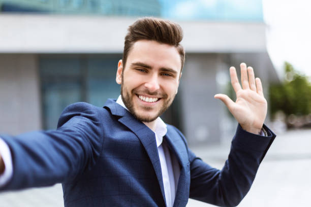 istock Handsome millennial businessman taking selfie with mobile device at city centre 1250214647