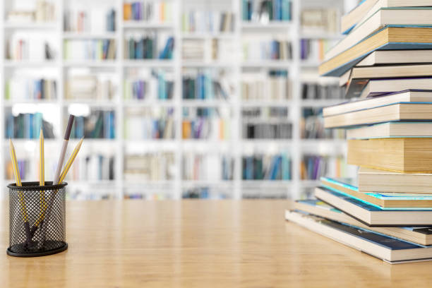 drewniane biurko i książki z tłem biblioteki. - bookshelf book table stack zdjęcia i obrazy z banku zdjęć