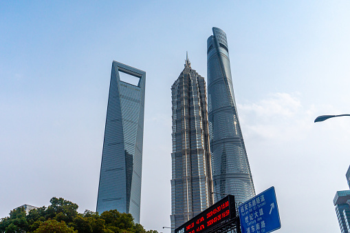 Shanghai, China - Mar 22, 2020: The Skyscrapers in Lujiazui financial district of Shanghai China. The Shanghai Center Tower, Jin Mao Tower and Shanghai World Financial Center. Road sign, stock board