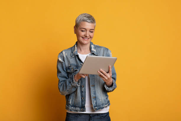 istock Great App. Beautiful middle-aged woman in stylish clothes using digital tablet 1250217031