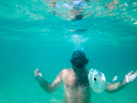 A young man snorkeling under water