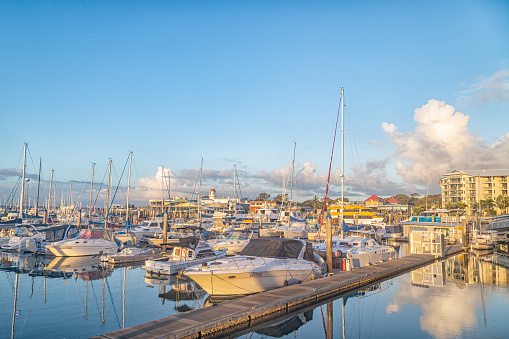 Looking across the boats moored in the boat harbour just after sunrise on a calm day