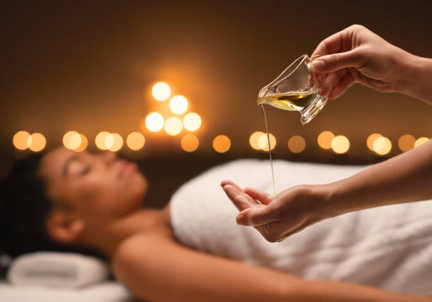 terapeuta aplicando aceite de masaje en las manos antes de la terapia - aromaterapia fotografías e imágenes de stock