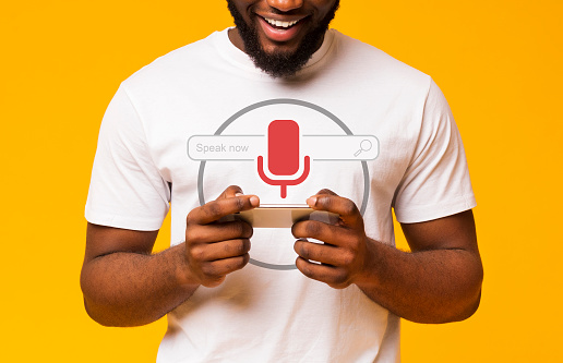 African Guy Using Voice Search On Smart Phone Standing Over Yellow Studio Background. Cropped, Collage