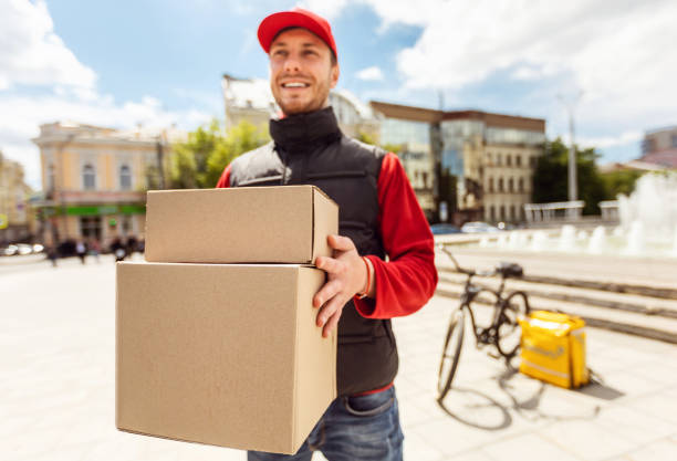 istock Courier Man Delivering Boxes, Parcels And Food In City 1250220530