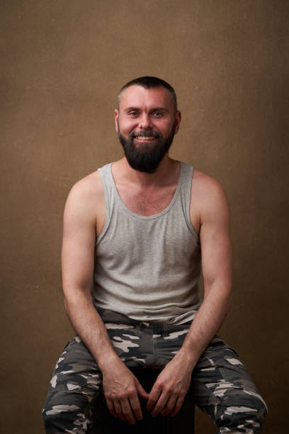 homme barbu fort. verticale d’un bel homme avec une barbe - camouflage pants photos et images de collection