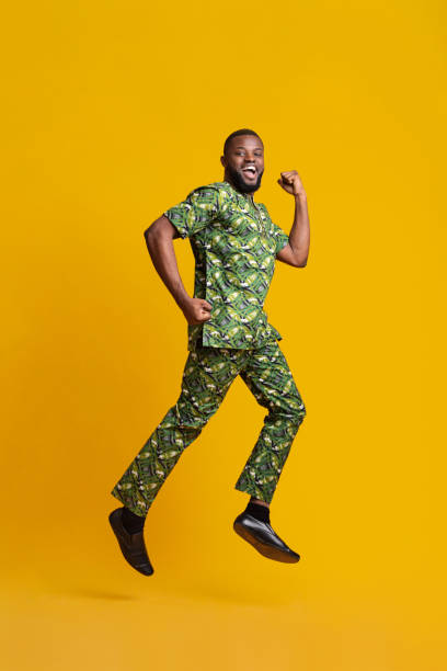 istock Joyful black man jumping up over yellow background 1250222573