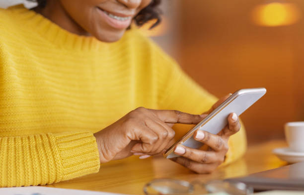 istock Cropped of black lady using mobile phone 1250222692