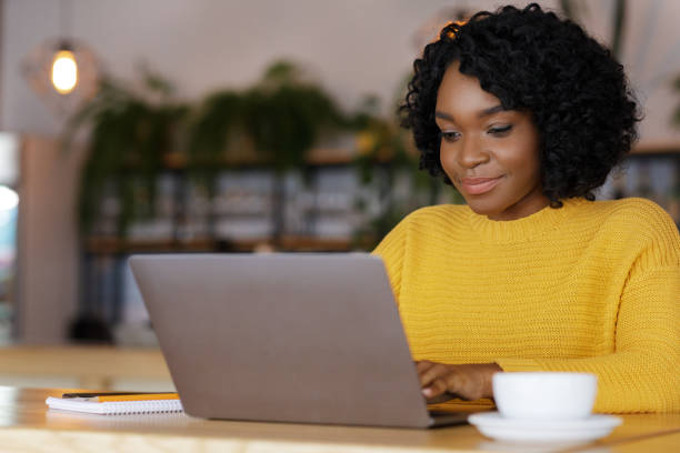 istock Female entrepreneur chatting with clients, using laptop at cafe 1250222719