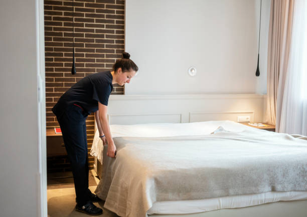istock Maid doing the bed, preparing hotel room for guests 1250222891