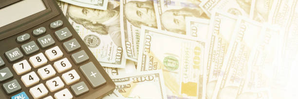istock calculator with grey and white buttons lies on dollars pile 1250223290