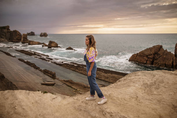 istock Young woman standing by the sea 1250225570