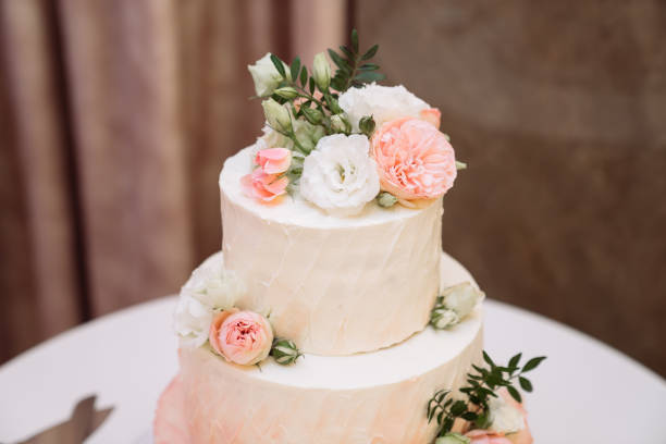 istock Big white wedding cake with pink roses on table 1250225672