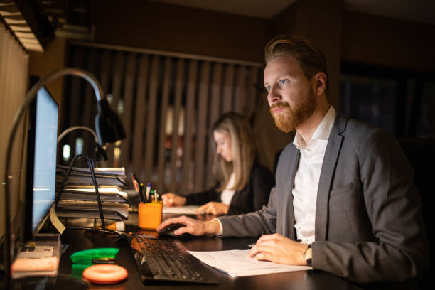 istock Dedicated employees working late at night at office 1250227813