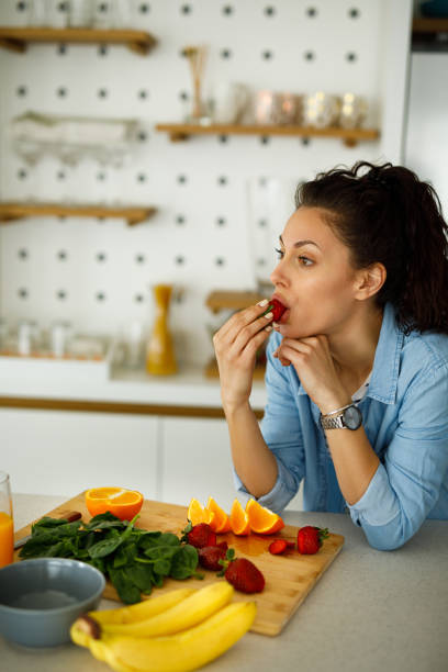 istock Young woman making a healthy snack with fruit at home 1250228245