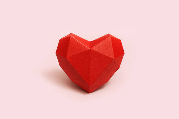 クリーム色の背景に赤い多角形の紙のハート形状。バレンタインデーのためのコピースペースと休日の背景。ラブコンセプト。プレーンカラー。最小限のスタイル。 - valentines day origami romance love ストックフォトと画像