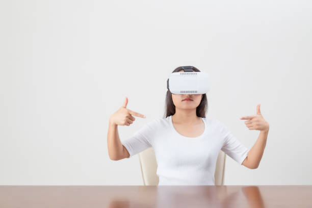 istock Young woman acting while wearing VR device or virtual reality glasses over white background. 1250228374