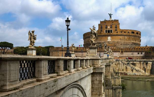 Rome, Italy, May 7, 2018: Castel Sant'Angelo and Ponte Sant'Angelo seen from the left bank of the Tiber River. The Castel was built between 135-139. It has been demolished, repaired and rebuilt several times over the years. Originally it was built by the Roman Emperor Hadrian as a family mausoleum, later served as a papal fortress connected by a tunnel in the walls with the Vatican, residences and prisons. It currently houses a museum dedicated to the history of the building and the city of Rome.