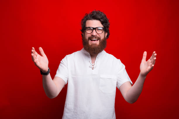 istock Portrait of smiling young bearded man making welcome gesture 1250230102