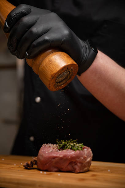 istock chef in black gloves marinates meat steak 1250231231