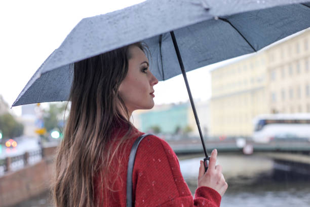 istock Girl in red with black umbrella. Autumn. 1250235721