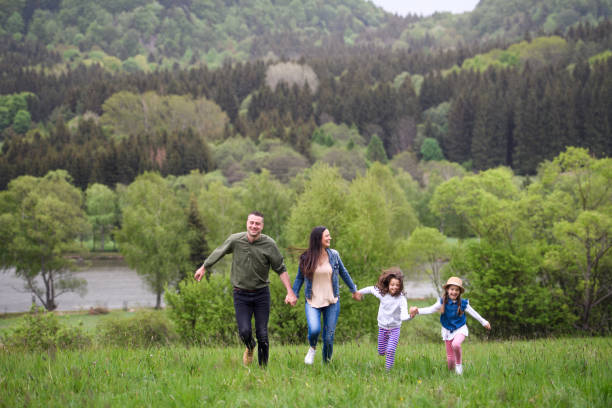 istock Happy family with two small daughters running outdoors in spring nature. 1250237801