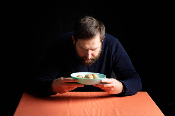 istock the man carefully looks at a plate in which potatoes 1250241949