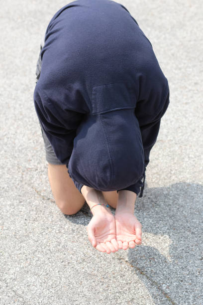 istock homeless man with hooded sweatshirt asks for alms by kneeling on 1250242075