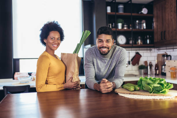 istock Happy african-american couple together in their kitchen at home 1250242582