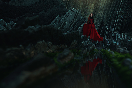 Mysterious woman standing on stones in a fairytale, red blue and green colors