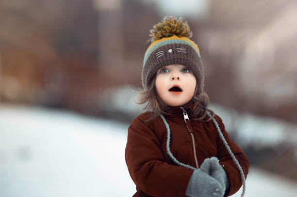 flocons de neige et magie... si surpris et heureux - christmas child baby surprise photos et images de collection