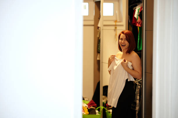 istock Redhead looking at camera, changing clothes in wardrobe room 1250244940