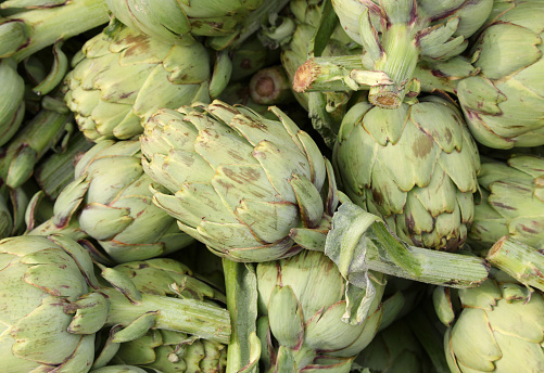 background of green big artichokes for sale at stand