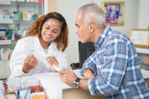 las mujeres farmacéuticas mantienen las recetas de los clientes en las farmacias. - pharmacist mature adult smiling senior adult fotografías e imágenes de stock