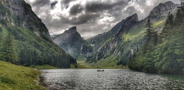 Family on boat on Seealpsee lake in Swiss Alps  in summer. Shot on camera film
