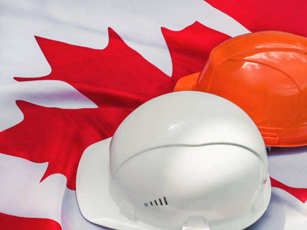 istock Canadian flag and two protective hardhats. Close-up 1250248533