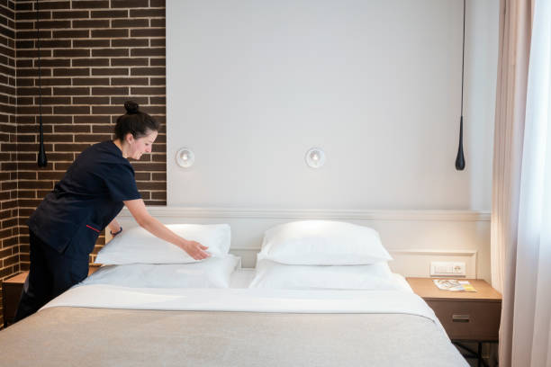 istock Maid doing the bed, preparing hotel room for guests 1250249994