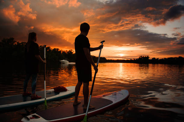 istock two people on sup boards on the river at sunset 1250250716