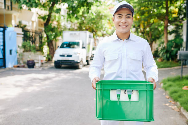 fröhliche lieferung mann mit milch - milkman stock-fotos und bilder