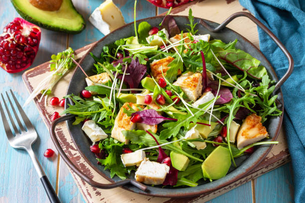 summer arugula salad with chicken, avocado, pomegranate and cheese on wooden table. - chicken salad grilled chicken grilled imagens e fotografias de stock