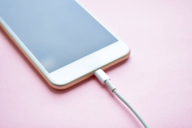 Charging a mobile phone connected to electricity for recharging.Copy space Charging a mobile phone connected to electricity for recharging.Copy space battery charger photos stock pictures, royalty-free photos & images