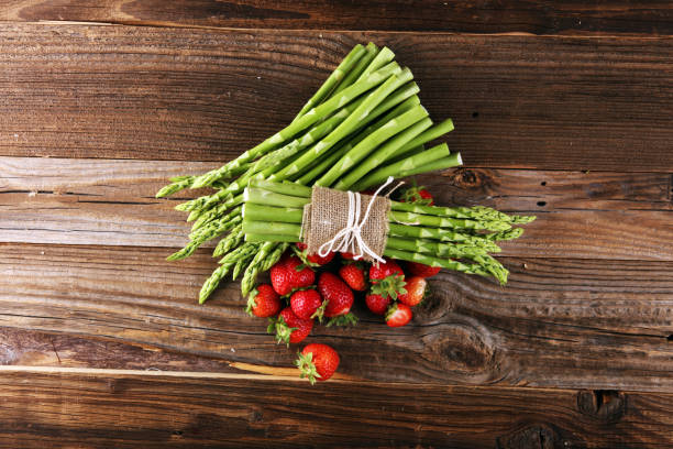 istock green asparagus with strawberries on wooden table 1250257784