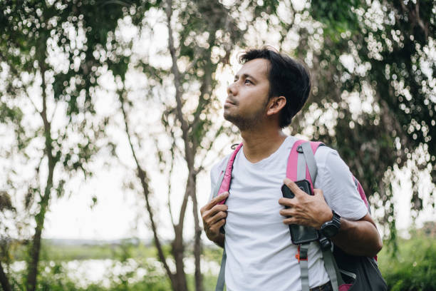 istock Young Asian man traveling backpacker in the forest 1250261076