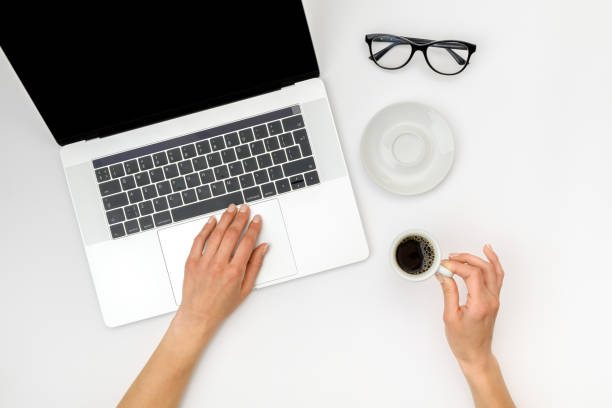 istock Top view of beautiful woman 's hands using laptop placed on white desktop. Flat lay 1250267736
