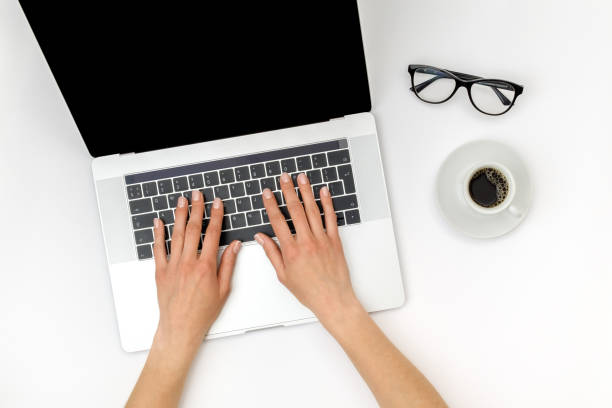istock Top view of beautiful woman 's hands using laptop placed on white desktop. Flat lay 1250267739