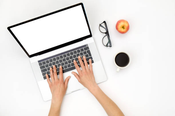 istock Home office workspace mockup. Laptop with blank screen, hands and accessories on white background. Flat lay. Top view 1250267744