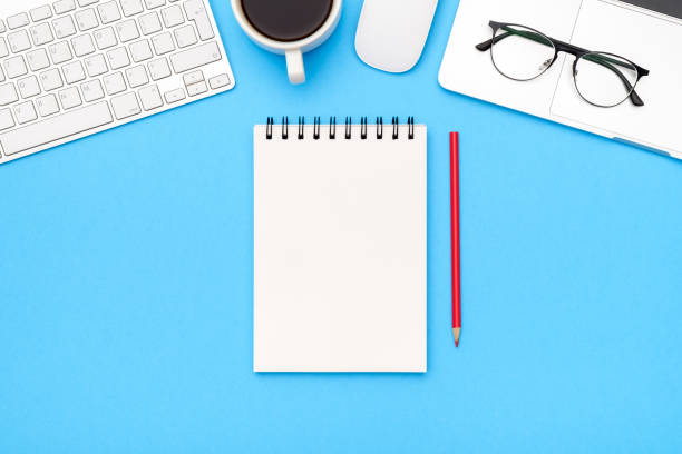 istock Minimal workplace with laptop and blank notepad on colored background. Top view. Flat lay 1250267824