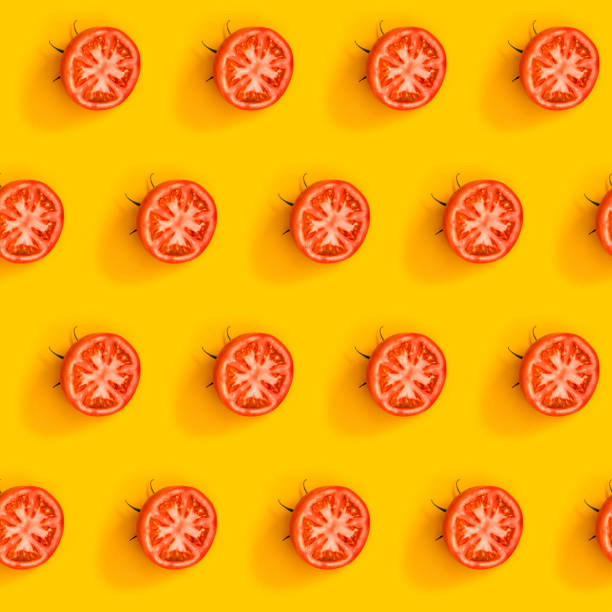 istock Diagonal pattern from ripe juicy tomatoes cut in half on bright yellow background. Creative minimalist flat lay. Vitamins vegan healthy diet concept 1250268080